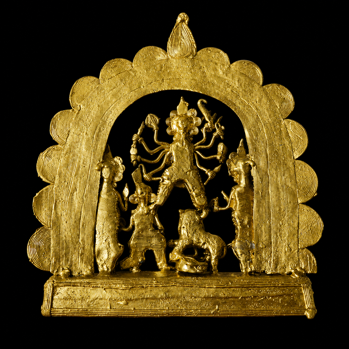 A golden Dokra Durga idol with metallic finish against a solid black background