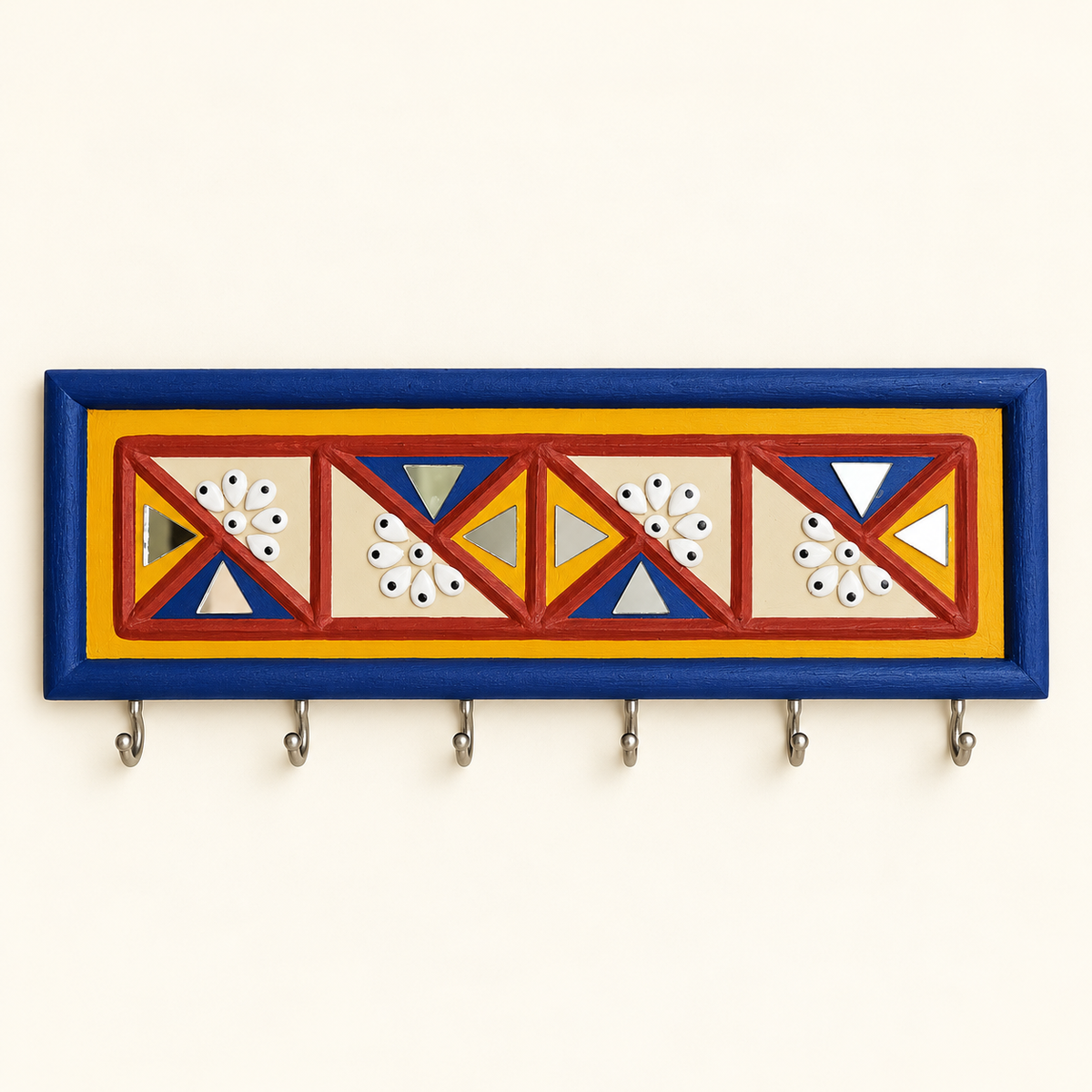 A rectangular decorative wall mounted key holder with five metal hooks, featuring a colorful Lippan art geometric pattern in red, blue, yellow, and cream, set against a plain off-white wall.