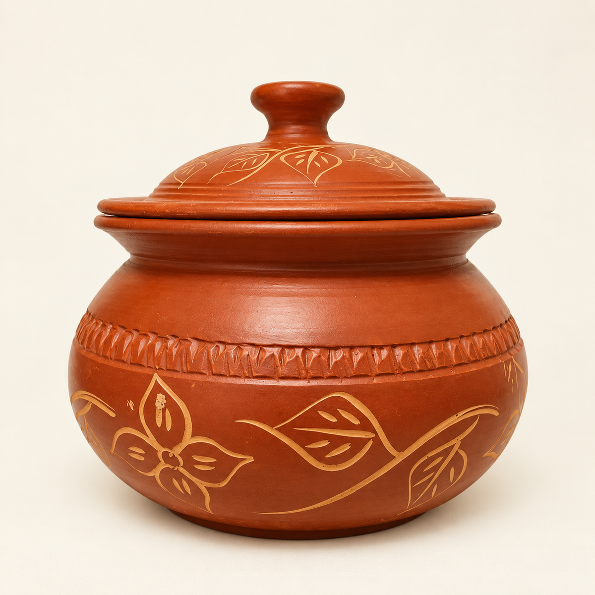 A terracotta clay lidded cooking pot with hand-painted gold floral and leaf patterns, shown on a clean off-white background.